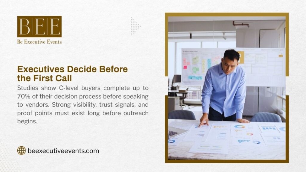 Executive reviewing data charts and analytics on desk with whiteboard strategy wall in background, illustrating how C-level buyers make purchasing decisions before initial vendor contact.