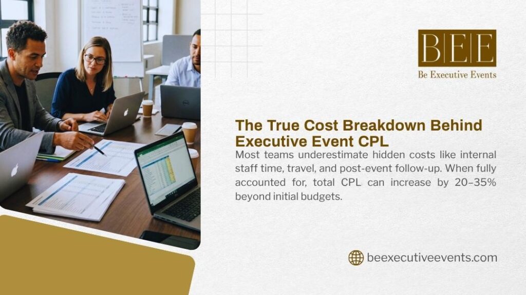 Three professionals in business casual attire seated at a conference table reviewing documents and working on laptops during an executive event planning meeting.